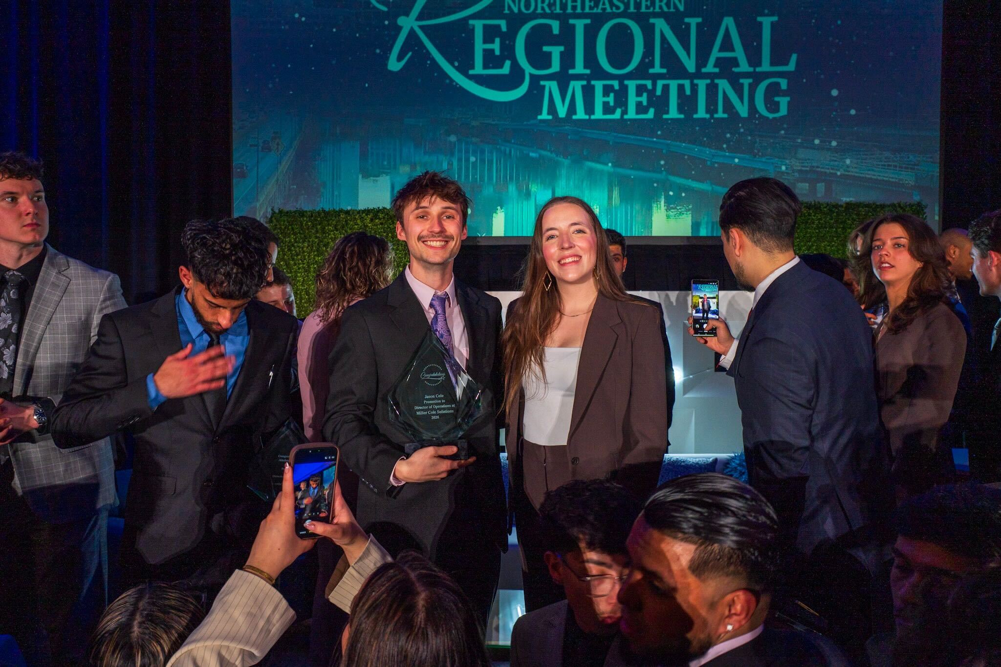 Miller Cole Solutions team celebrating an award at a regional meeting